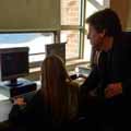 teacher working with a female student on the computer